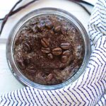 A glass jar filled with diy coffee body scrub.