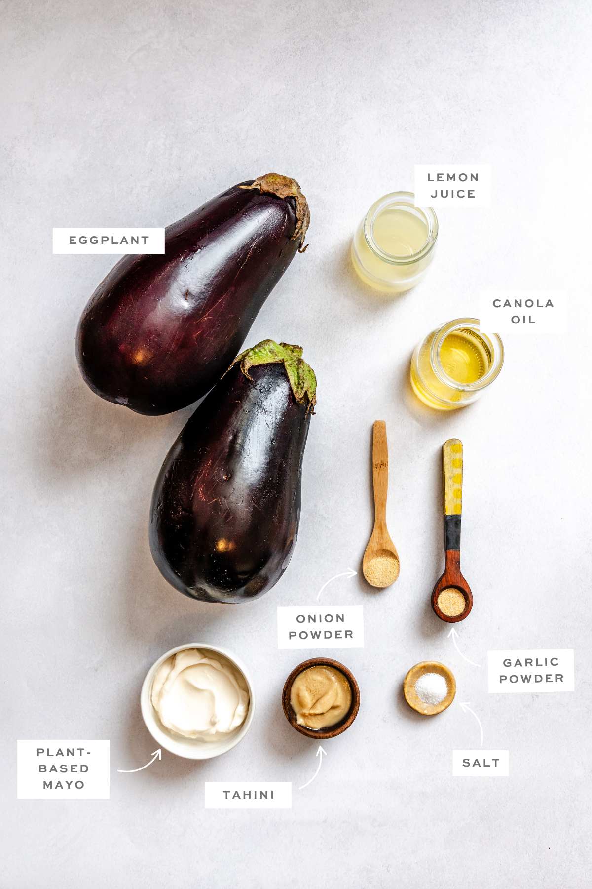 Gathered ingredients for this homemade eggplant dip measured out into individual bowls and measuring spoons with labels.