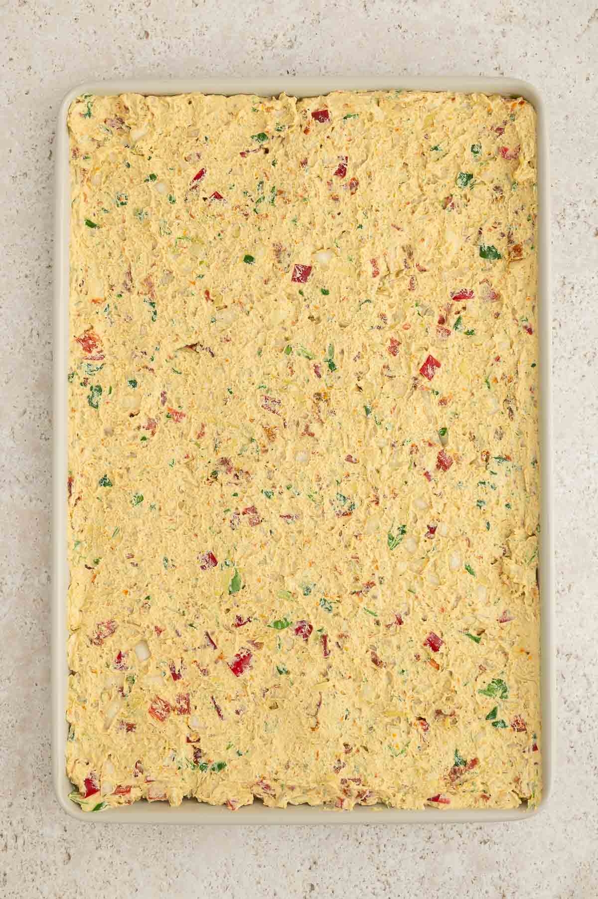 The vegan breakfast burrito tofu mixture spread evenly on a sheet pan.
