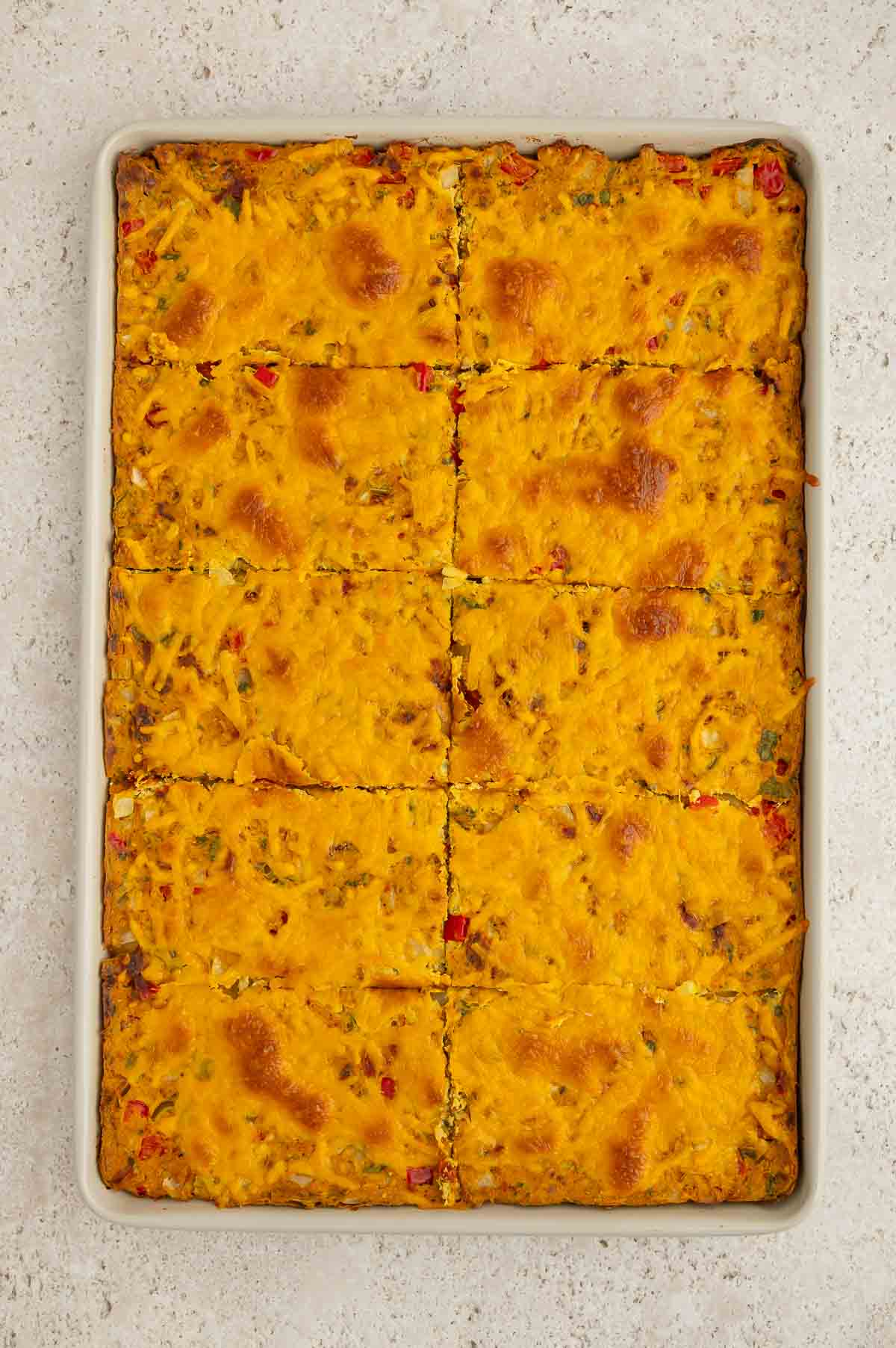 Baked vegan breakfast burrito filling a sheet plan, sliced into 10 even servings.