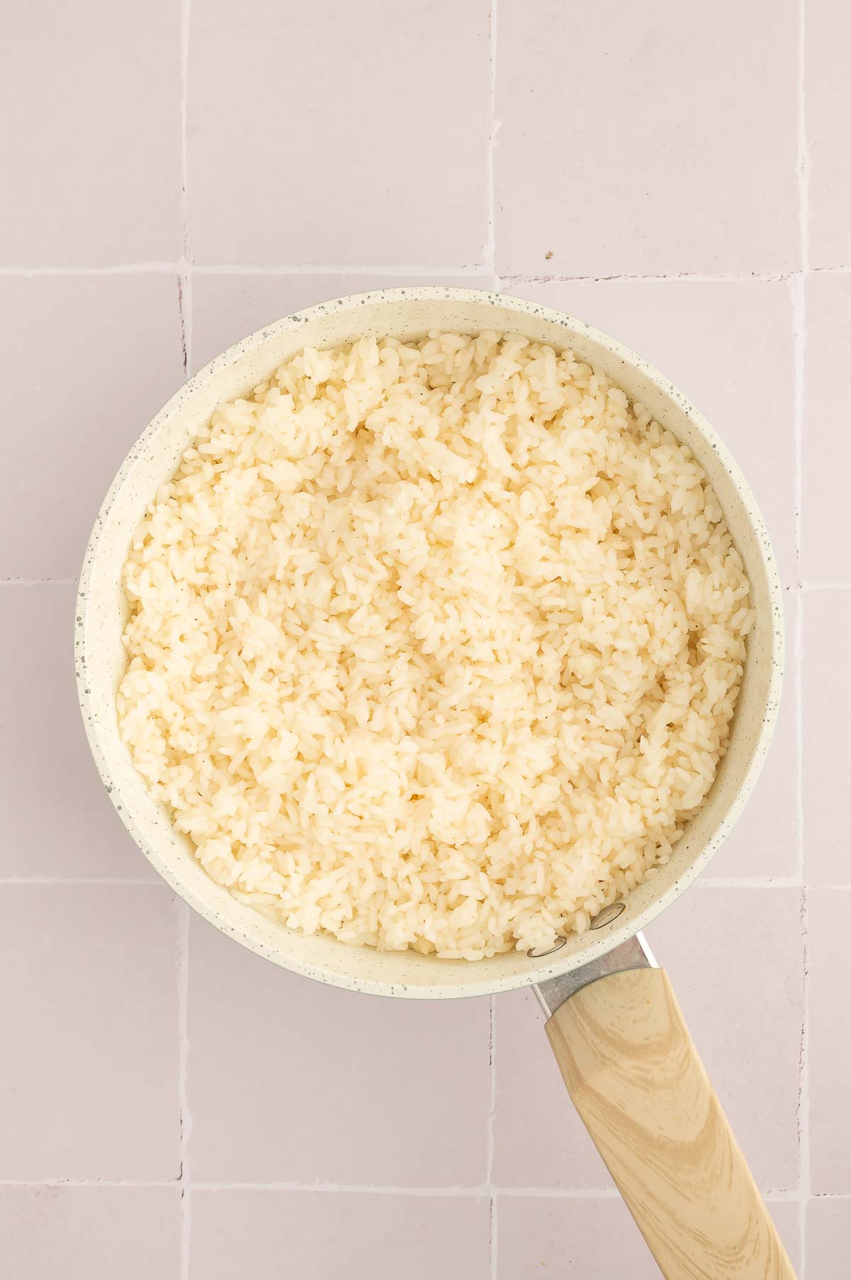 Fluffed up sushi rice in a pot with rice vinegar, sugar, and salt mixed in.