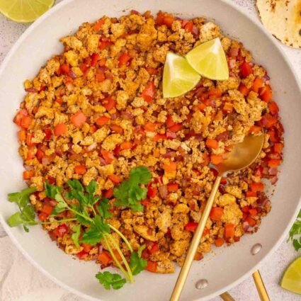 A bowl of tofu taco meat crumbles with a spoon.