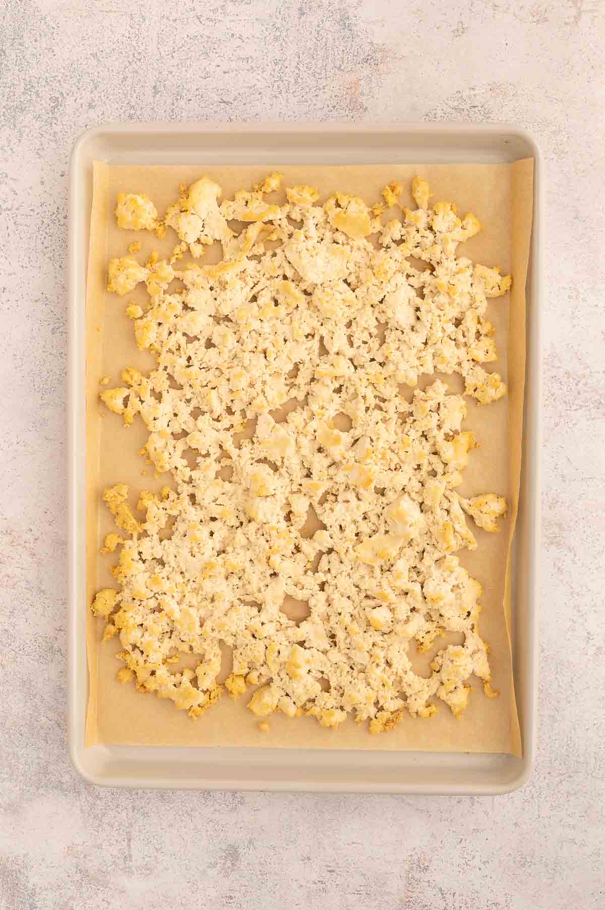Golden baked tofu crumbles on a baking tray.