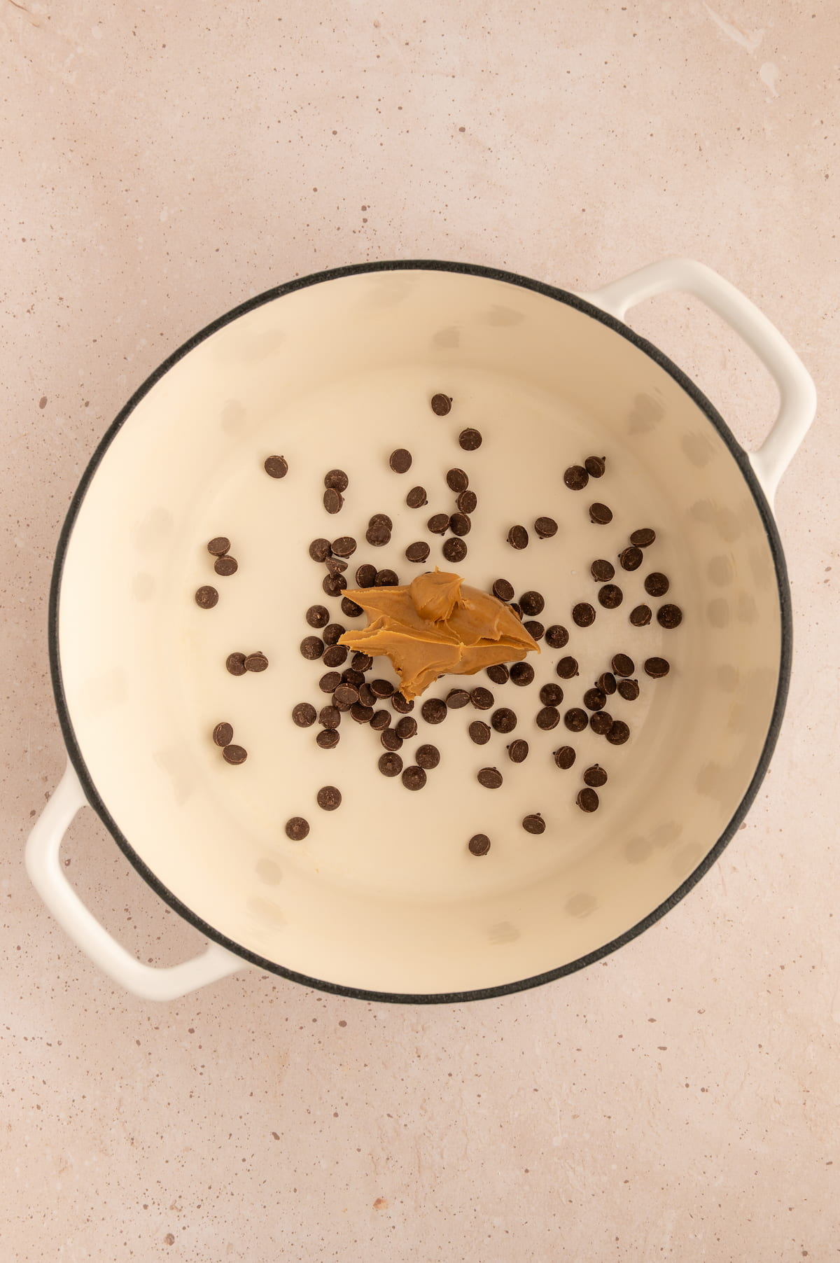 Dairy-free chocolate chips and peanut butter in a pot ready to be melted for this peanut butter chocolate popcorn recipe.
