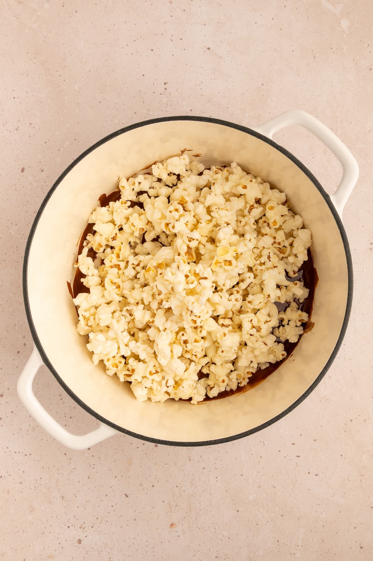 Popped popcorn added to the pot of melted chocolate and peanut butter.