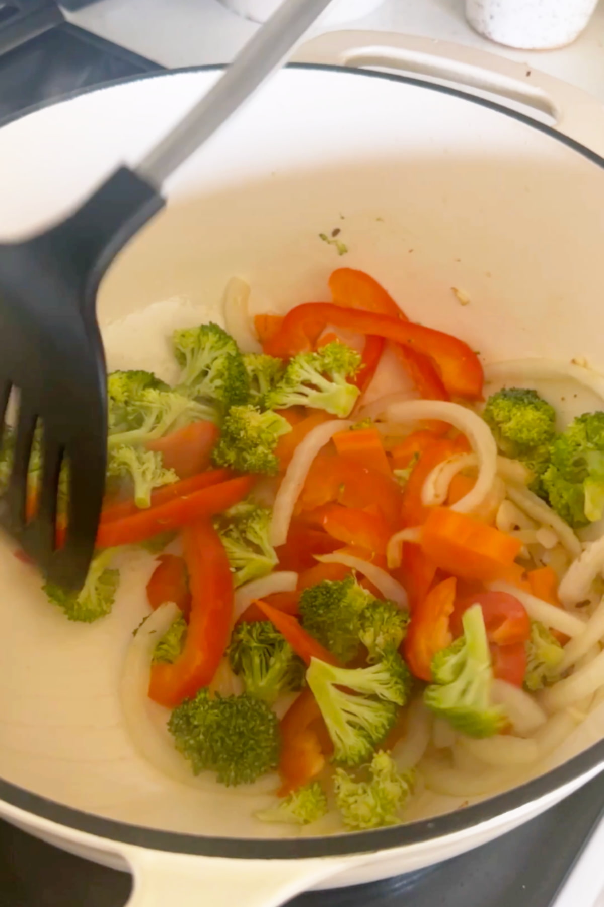 Aromatics and vegetables for the glass noodle soup recipe sauteeing in a dutch oven.