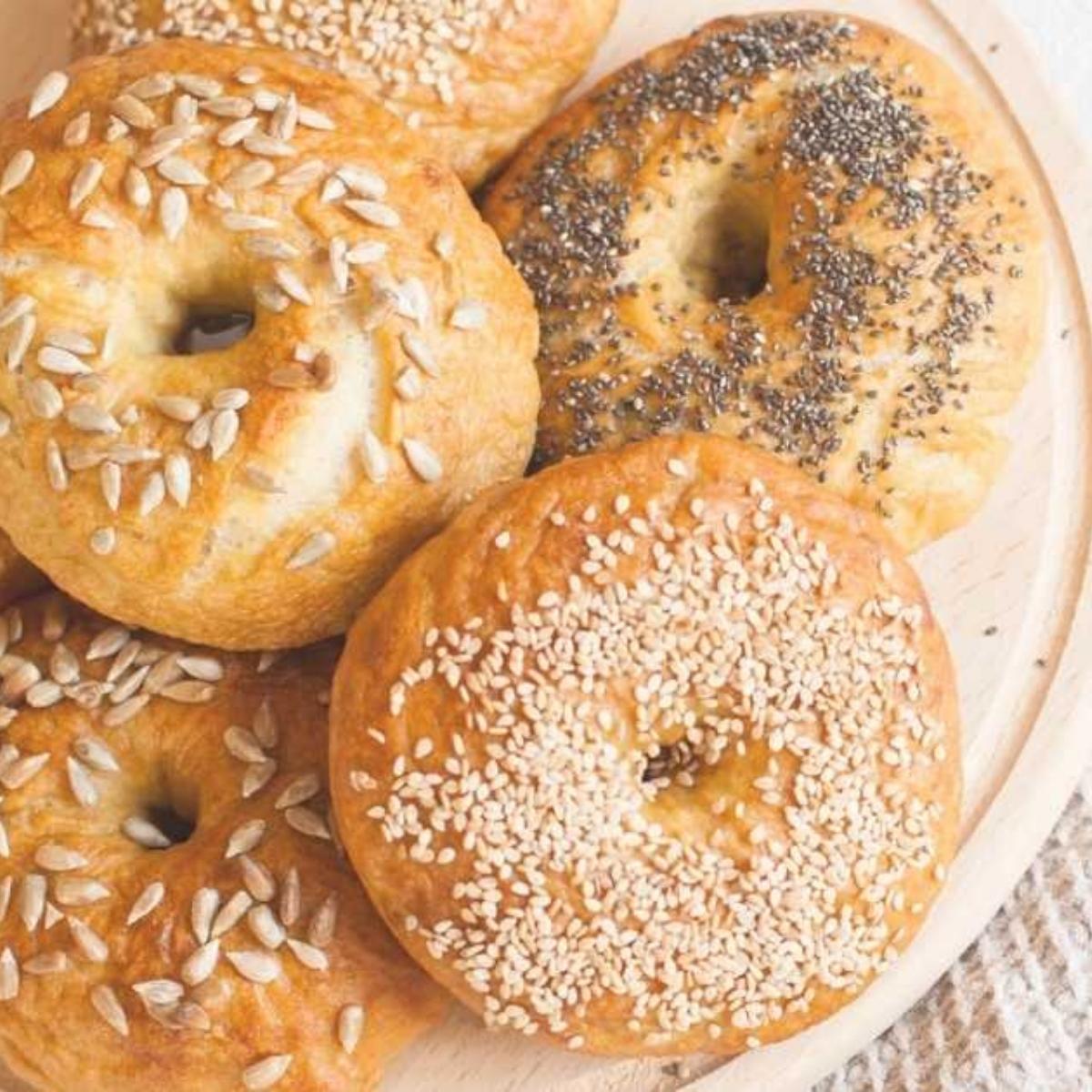 A plate full of vegan bagels, including everything and sesame topped bagels.