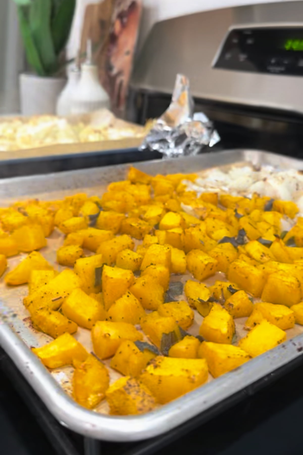 Roasted kabocha squash and onion on a sheet pan.