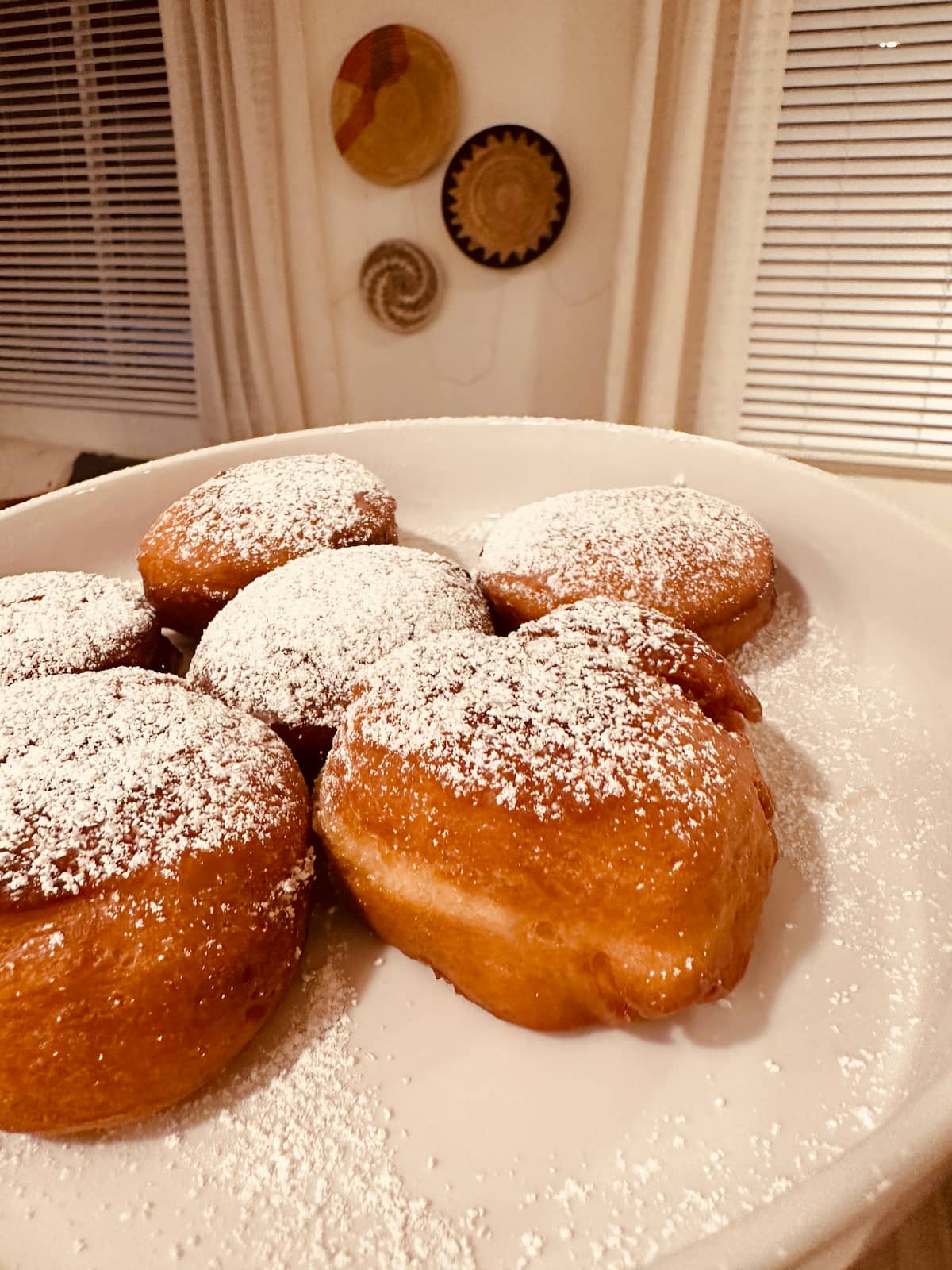 A plate of powdered vegan sufganiyot jelly donuts on a white plate.