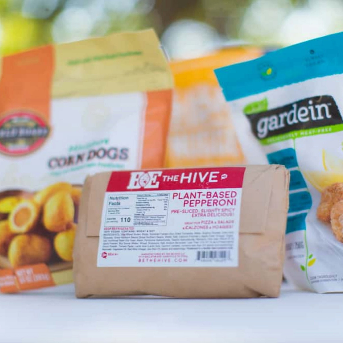 Packages of the best vegan meats photographed on a white tabletop outdoors.