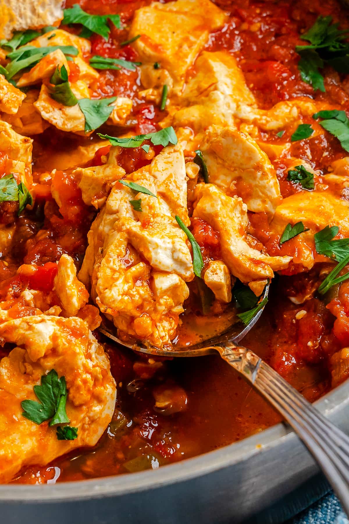 A close up spoonful of vegan shakshuka garnished with fresh parsley.