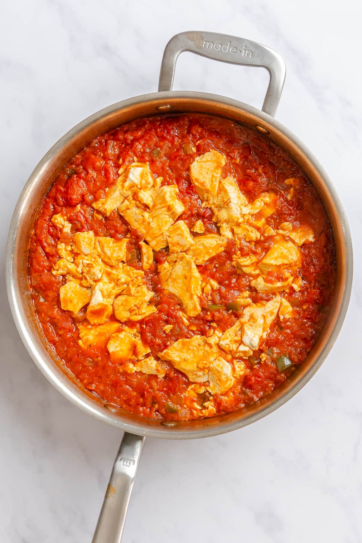 Silken tofu simmered in the tomato base of a vegan shakshuka recipe.