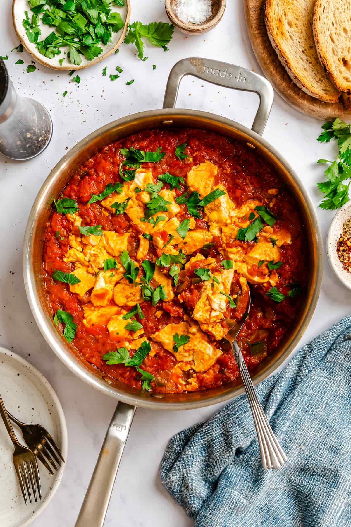 Finished vegan shakshuka dish in a skillet with fresh parsley.