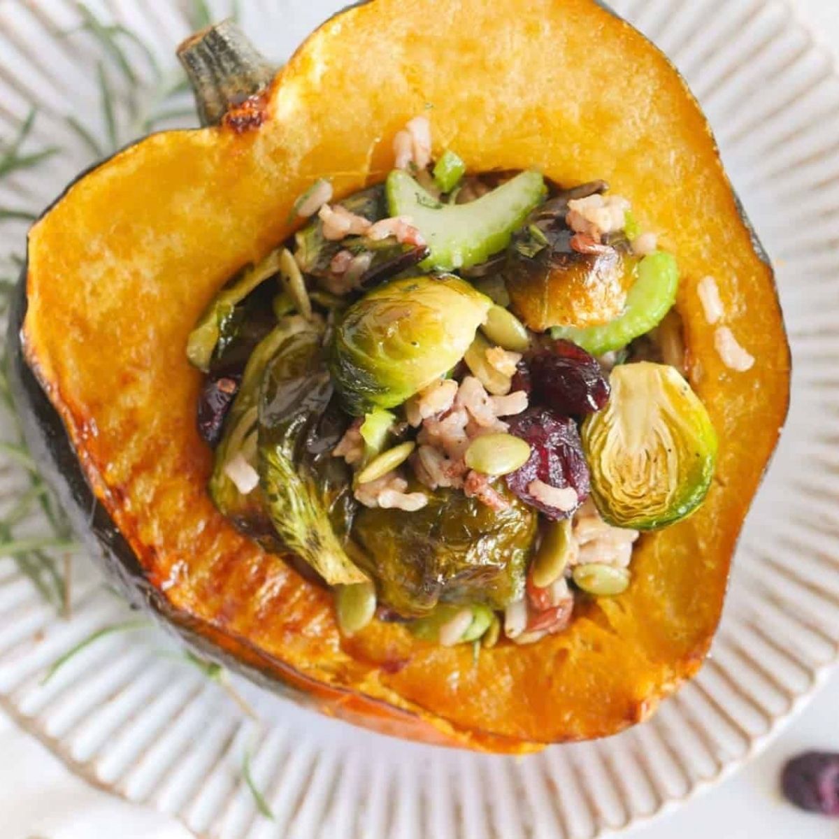 Stuffed acorn squash with wild rice recipe on a white plate.