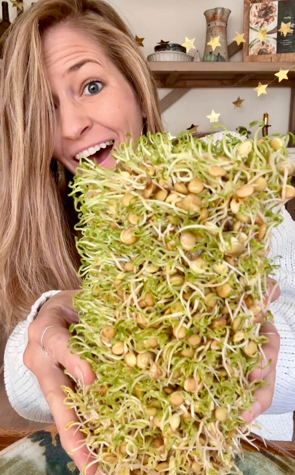 World of Vegan founder Michelle Cehn holding out a big batch of freshly harvested fluffy sprouts.
